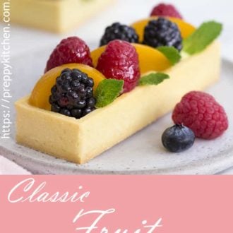 a photo of a rectangular fruit tart with a few sprigs of mint.