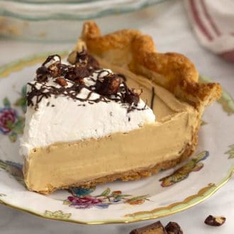 a piece of peanut butter pie topped with whipped cream and chocolate