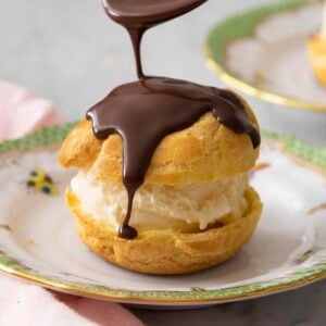 Close up of melted chocolate drizzling onto a profiterole.