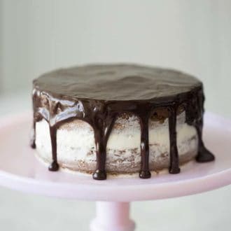 A chocolate almond cake on a pink cake stand