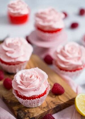 A photo showing a group of cupcakes topped with pink buttercream roses.