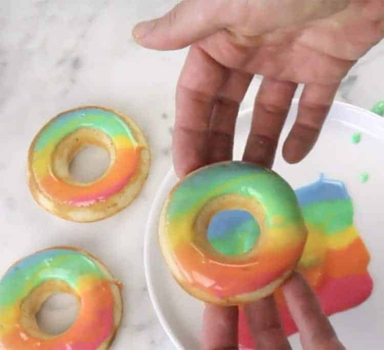 A donut just dipped in rainbow glaze