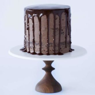 A photo of a Chocolate Chocolate Cake on a cake stand.