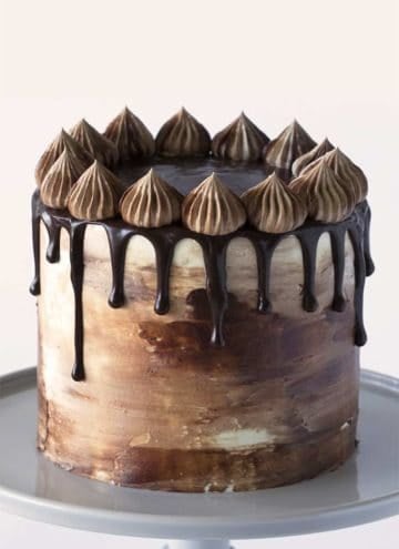 A chocolate peanut butter cake on a grey cake stand