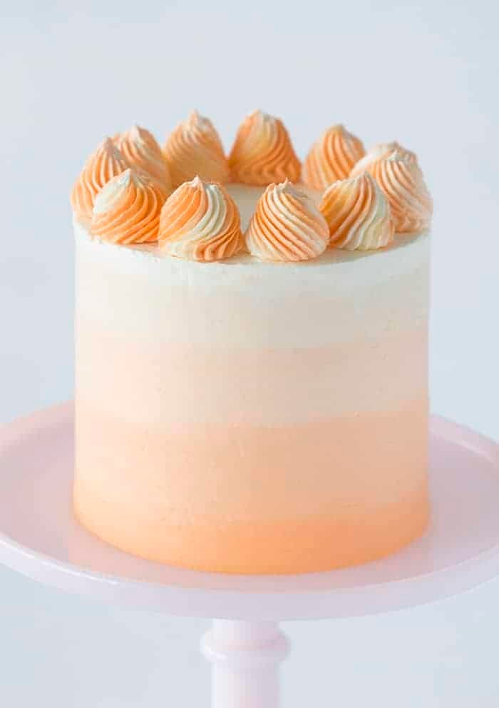 a photo showing a creamsicle cake with swirled orange and white dollops on top.