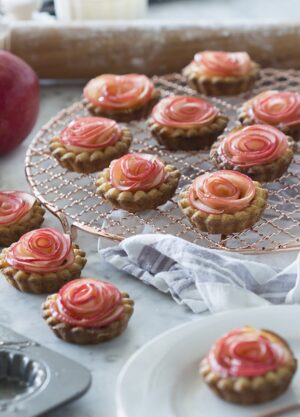 A photo of multiple apple rose tarts.