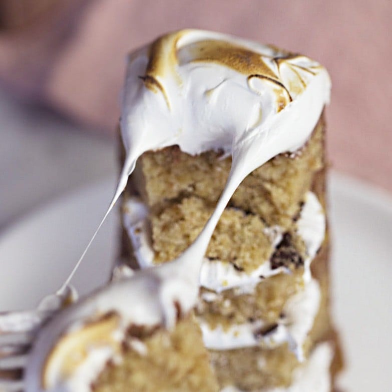 A photo of a bite being taken from a s'mores cake.