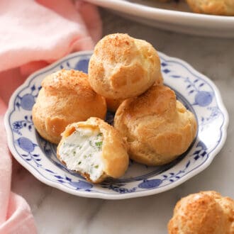 A group of cheese puffs on a blue and white plate.