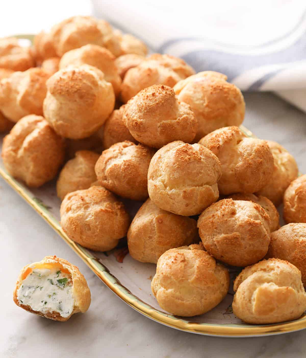 Many cheese puffs on a porcelain tray.