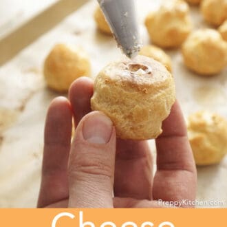 A cheese puffs being piped with goat cheese.