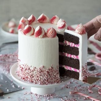 A photo showing a chcoclate peppermint cake with a piece being removed.