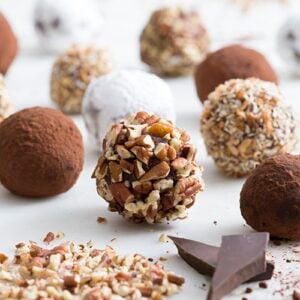 A photo of spherical brandies truffles on a white marble table.