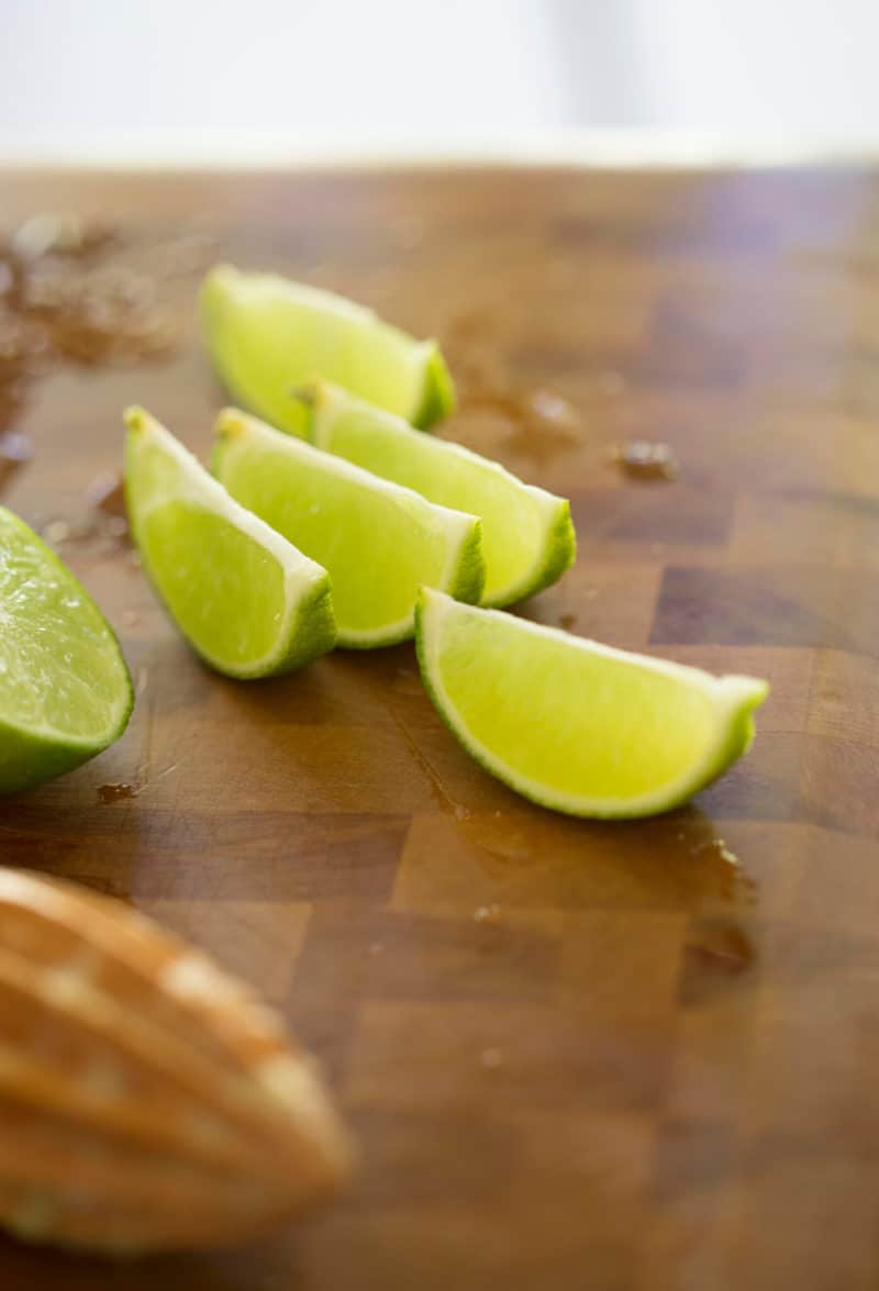 A photo of sliced limes on a cutting board.