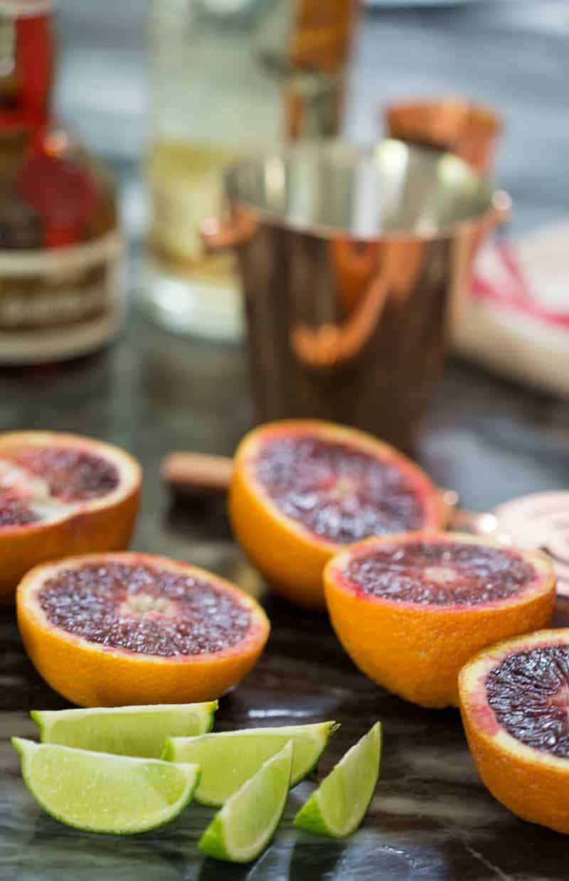 A photo of blood oranges and limes cut in half.