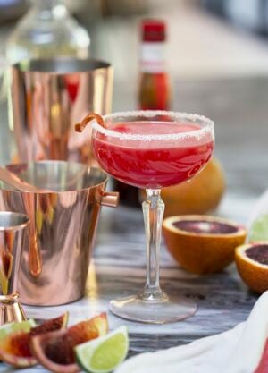 A photo of a Texas margarita in a coupe glass among copper bar tools.