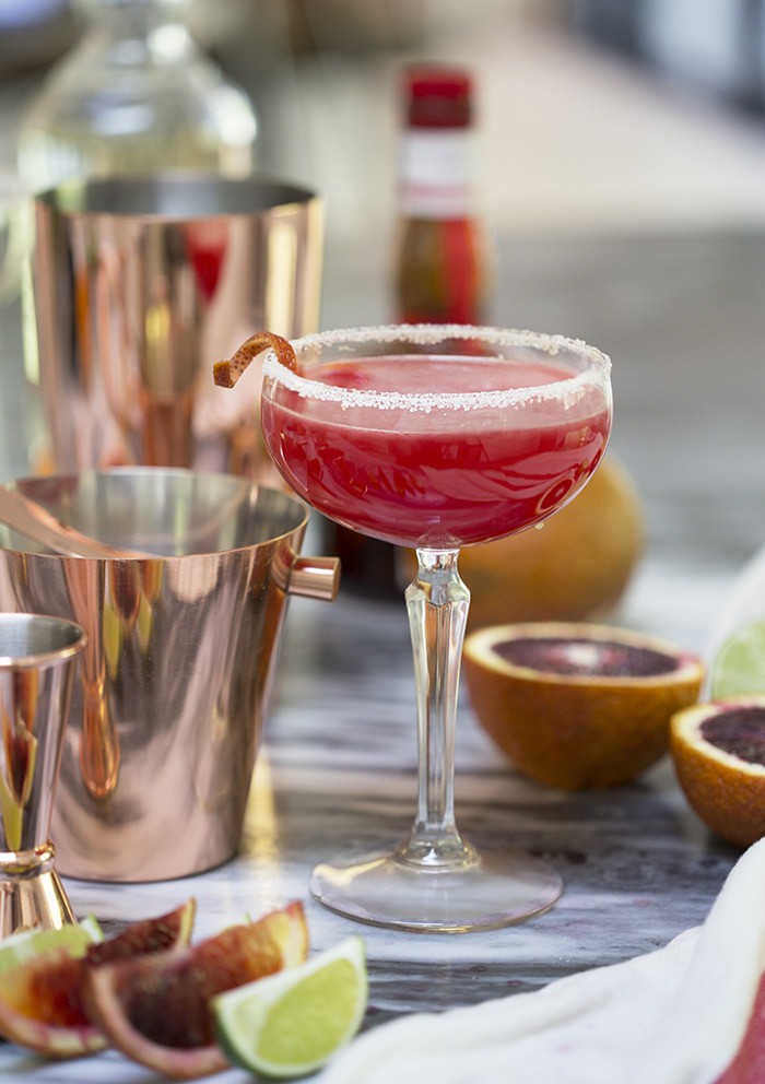 A photo of a Texas margarita in a coupe glass among copper bar tools.