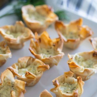 A photo of Cheesy Filo Cups on a white platter
