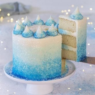 A photo of a blue ombre cake with a piece coming out.