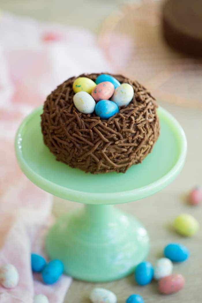 A photo of a Bird’s Nest Easter Cake on a mini cake stand.
