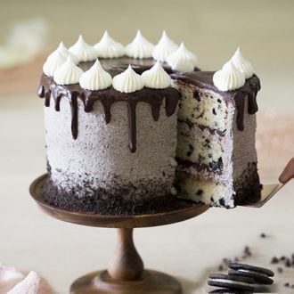 A close up photo of a Cookies and Cream Cake on a wooden cake stand