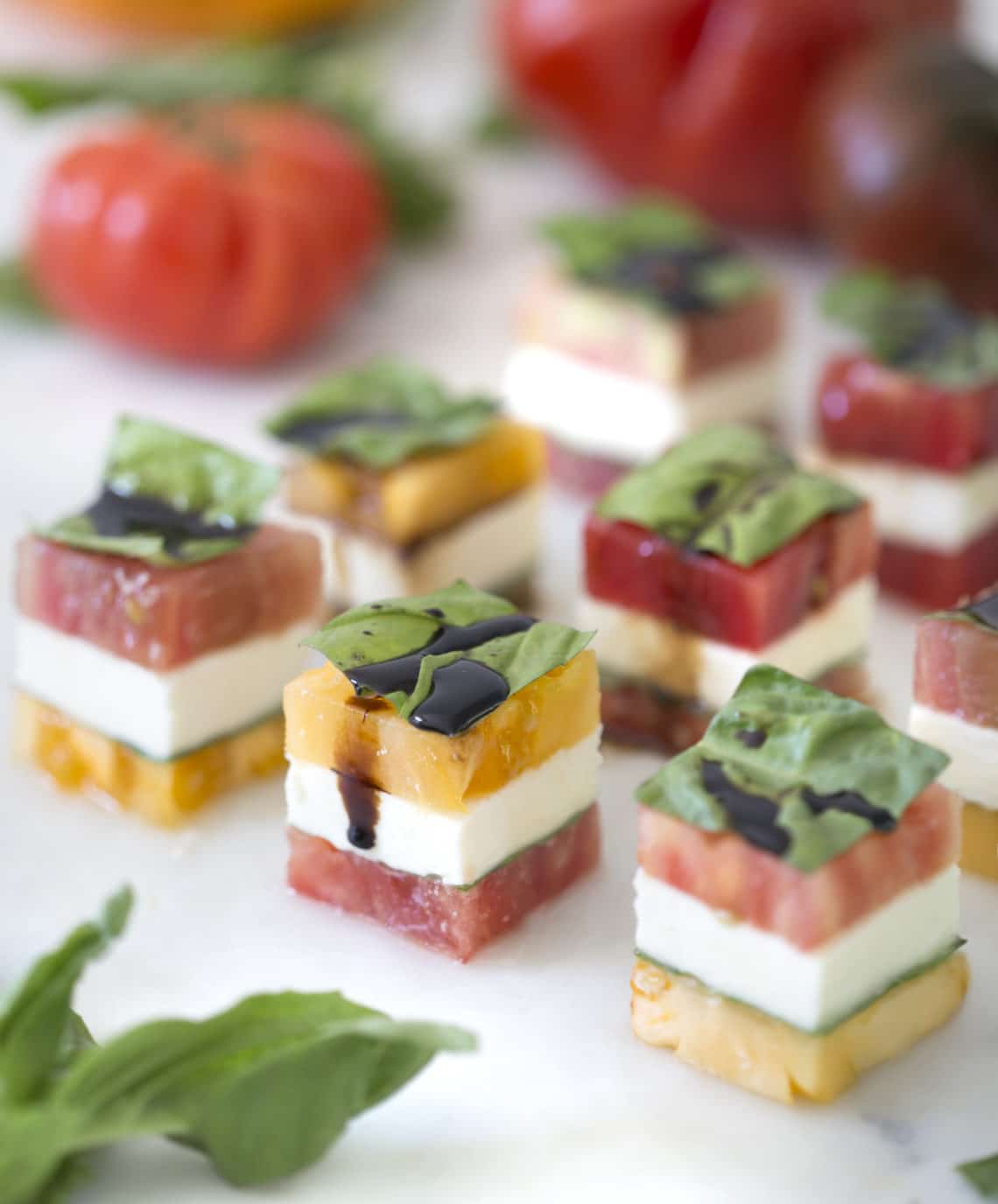 A fancy version of a caprese salad stacked and cut into cubes.