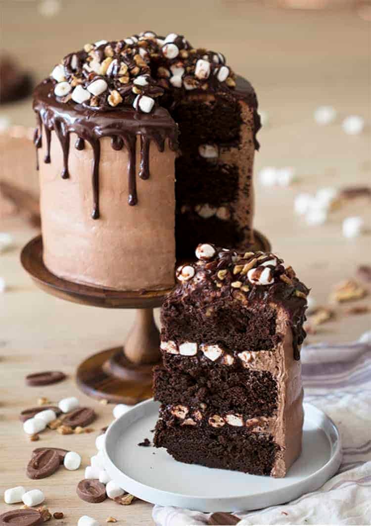 A Rocky Road Cake with a piece in the foreground on a small plate