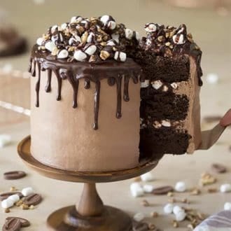 A Rocky Road Cake on a wooden cake stand