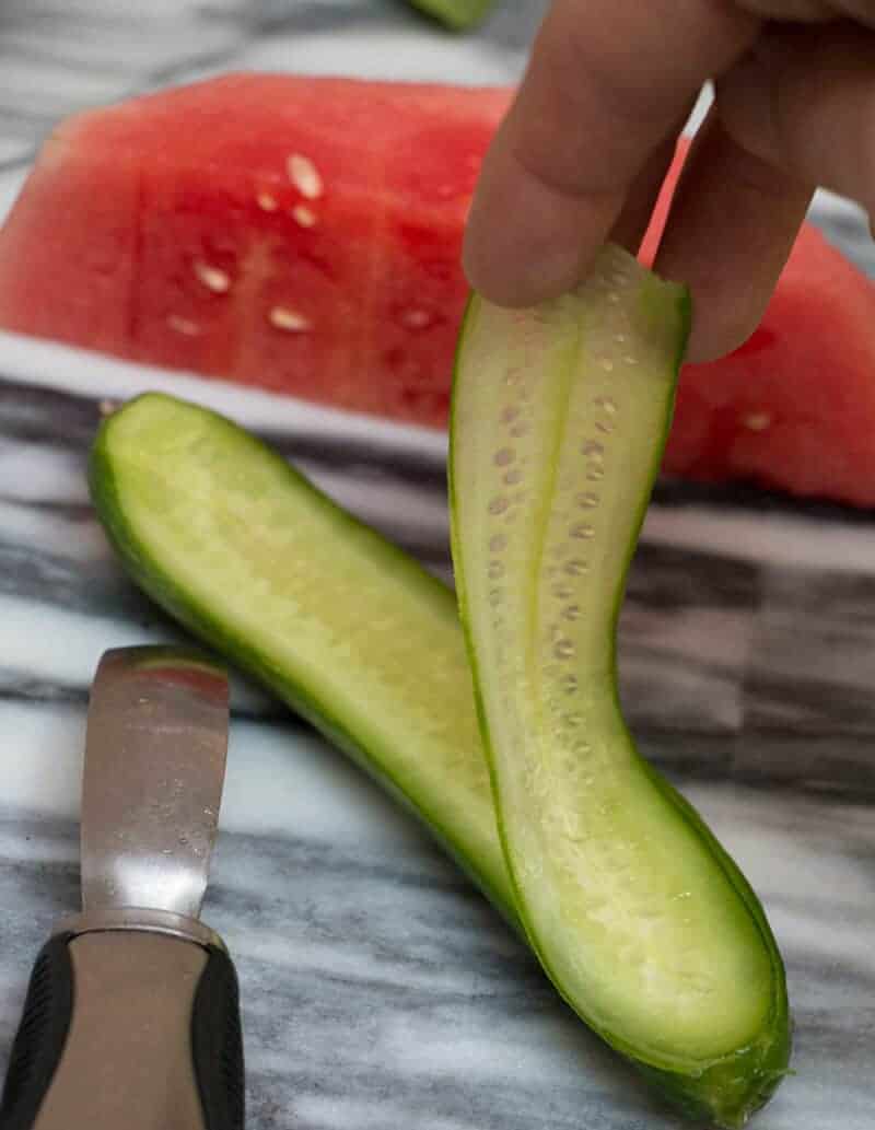 A photo of a cucumber being peeled.