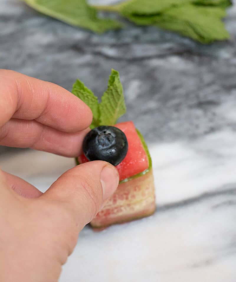 A process shot of a watermelon Canapé being made.
