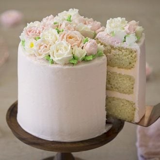 a photo of a cake covered in buttercream roses