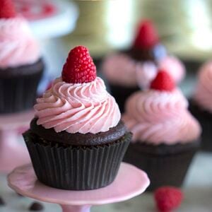 Photo of chocolate cupcakes topped with raspberry buttercream on a marble table