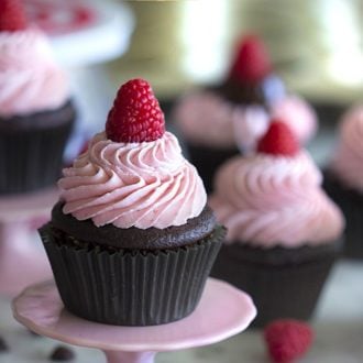 Photo of chocolate cupcakes topped with raspberry buttercream on a marble table