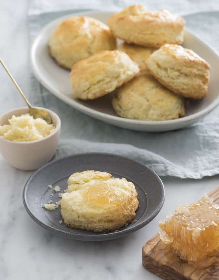 A photo of a buttermilk biscuit with a honey butter compound melting in the middle.