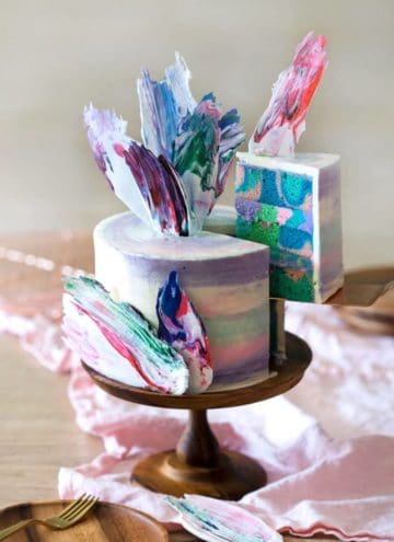 photo of a rainbow Cake on a wooden cake stand