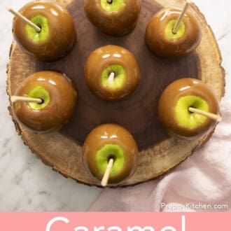 Pinterest graphic of an overhead view of caramel apples on a round wooden serving platter.