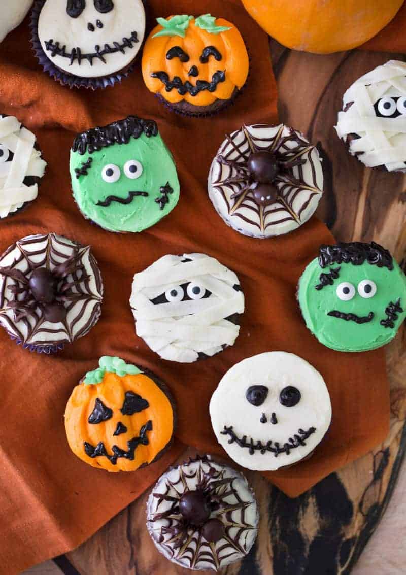 Overhead view of various cupcakes with Halloween decoration.