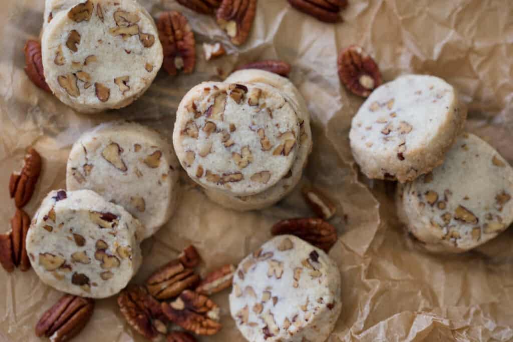 A photo of pecan shortbread cookies on parchment paper.