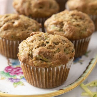 A group of zucchini muffins on a porcelain serving tray.