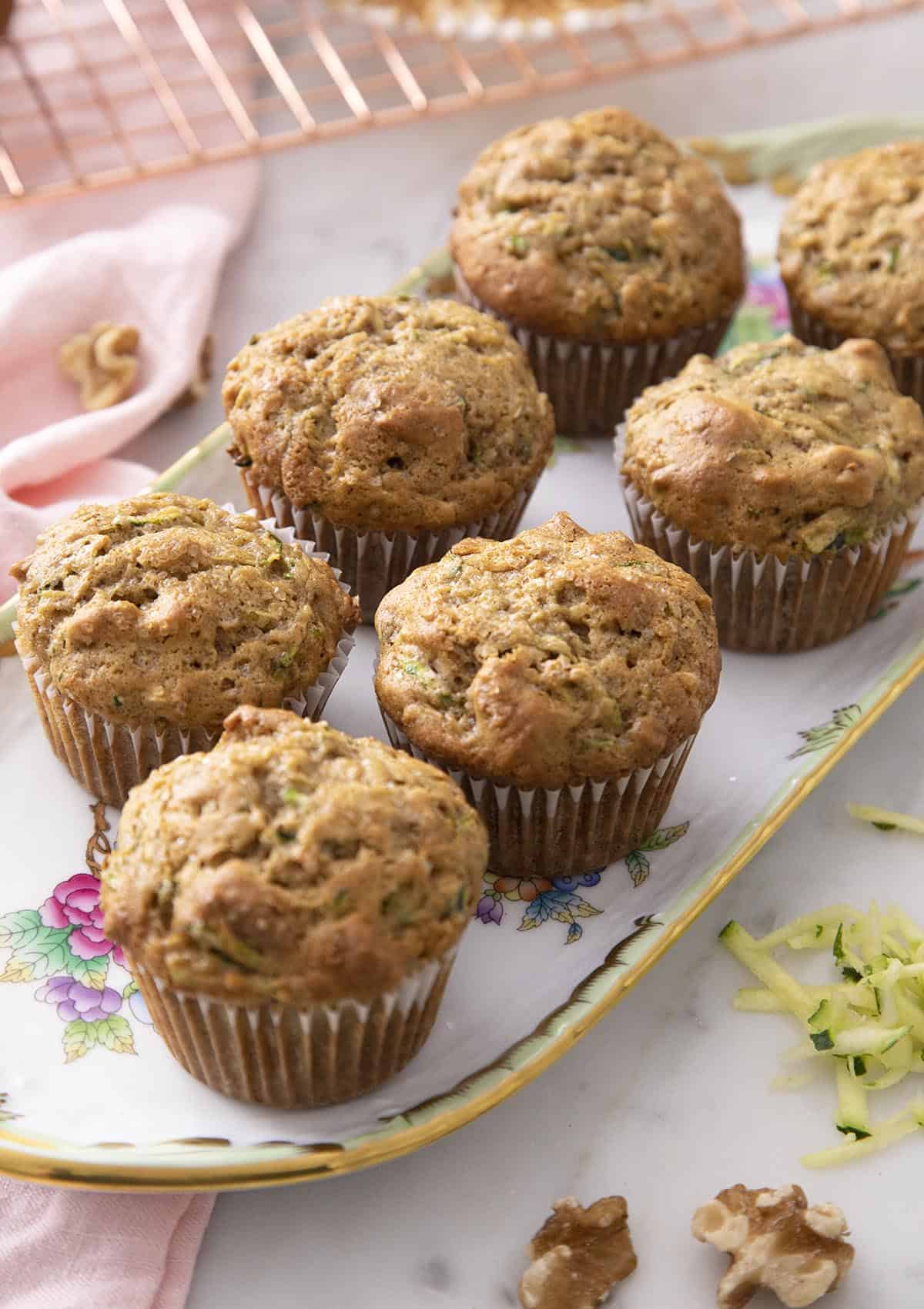 Zucchini muffins with toasted walnuts on a serving tray.