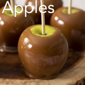 Several caramel apple on a piece of wood.