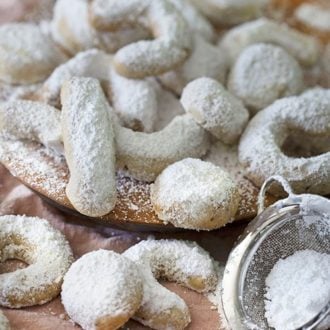 A photo of a group of Mexican wedding cookies on a wooden board