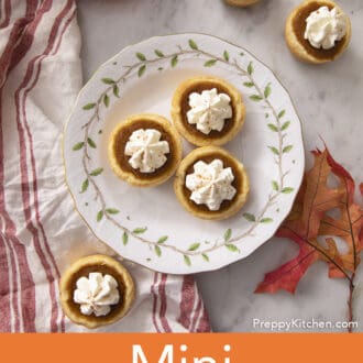 Five mini pumpkin pies on a marble counter.