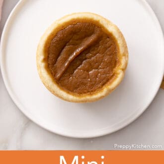 A mini pumpkin pie on a white plate.