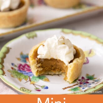 A mini pumpkin pie on a plate with a bite taken out.