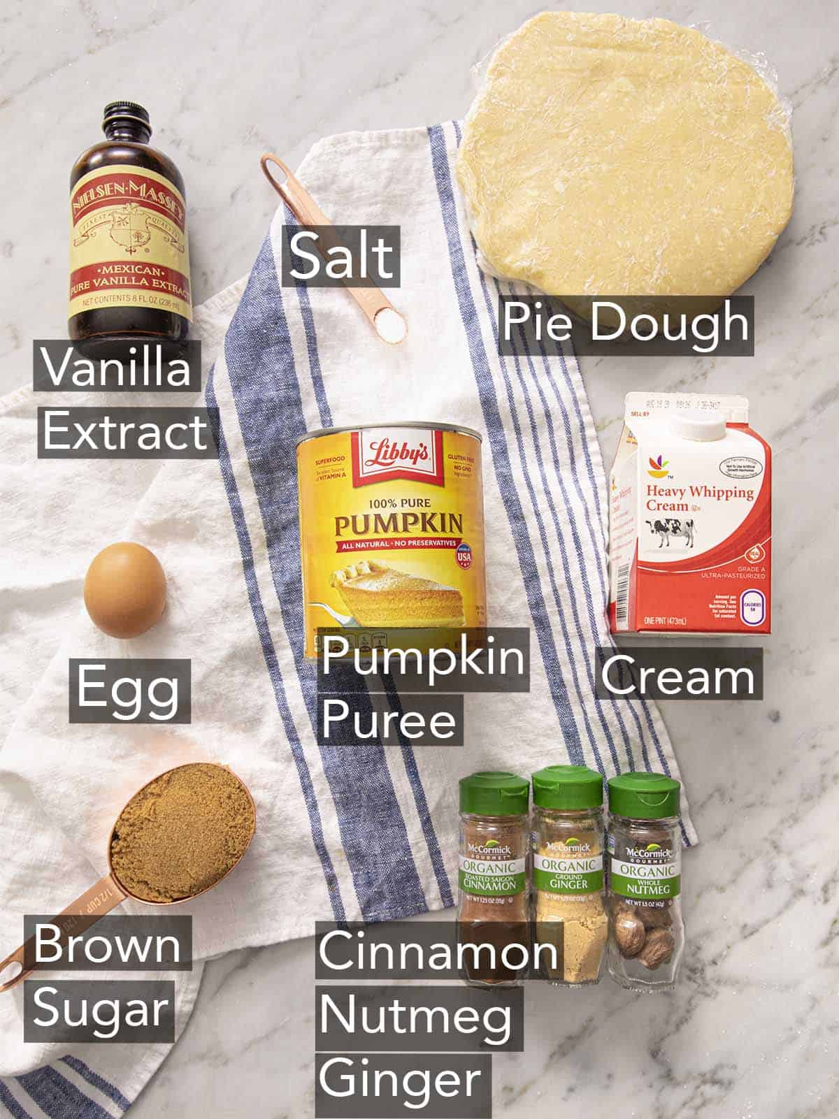 Ingredients for making mini pumpkin pies on a marble counter.