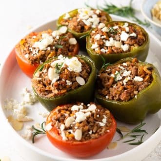 A photo of tomatoes and peppers stuffed with ground turkey and topped with feta cheese.