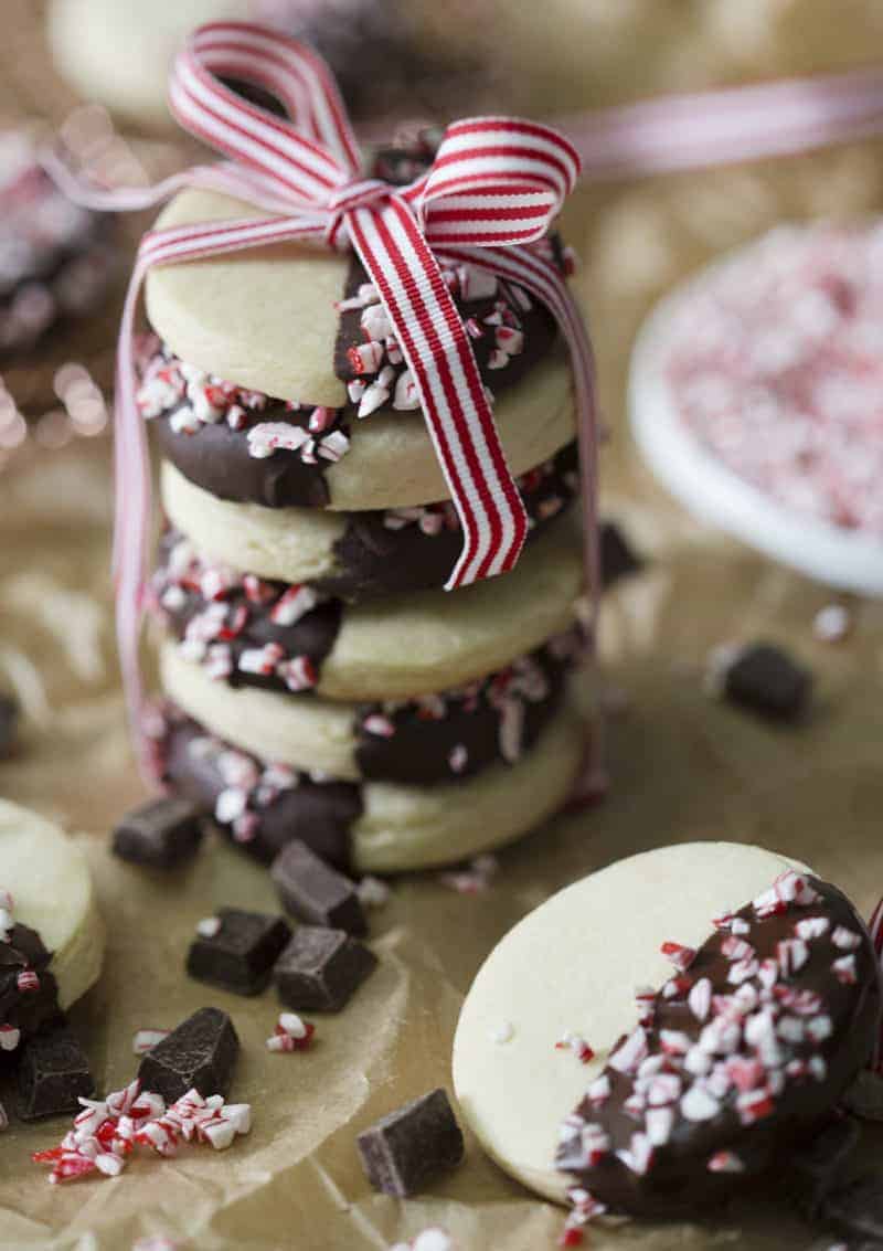 A photo of cookies that have been dipped in chocolate and peppermint, stacked on top of each other with a ribbon.
