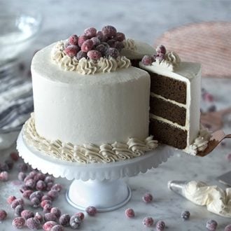 Photo of a Gingerbread Cake topped in sparkling cranberries with a piece coming out.