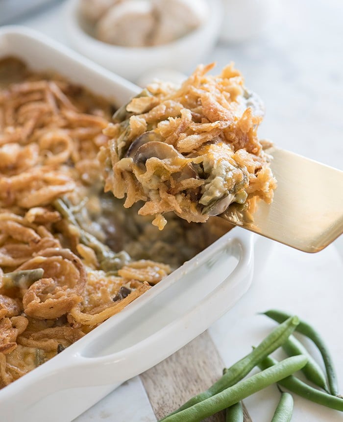 photo of green bean casserole being serves with a gold spatula