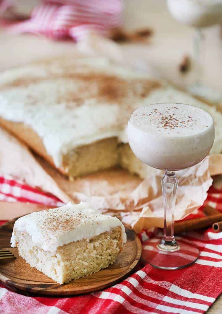 An eggnog sheet cake with a piece in the foreground.